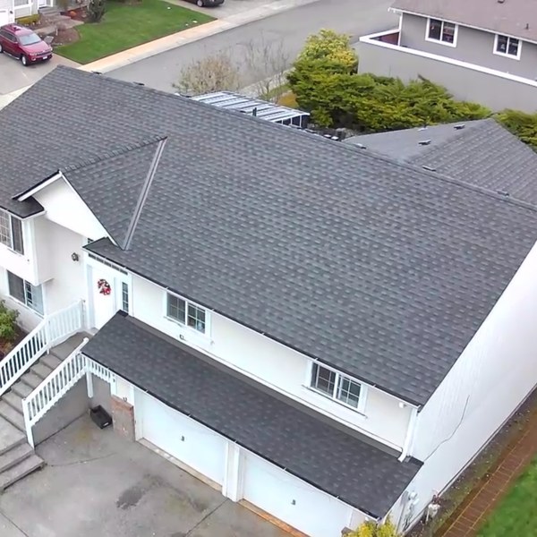 Finished dark shingle reroof on a white two story house
